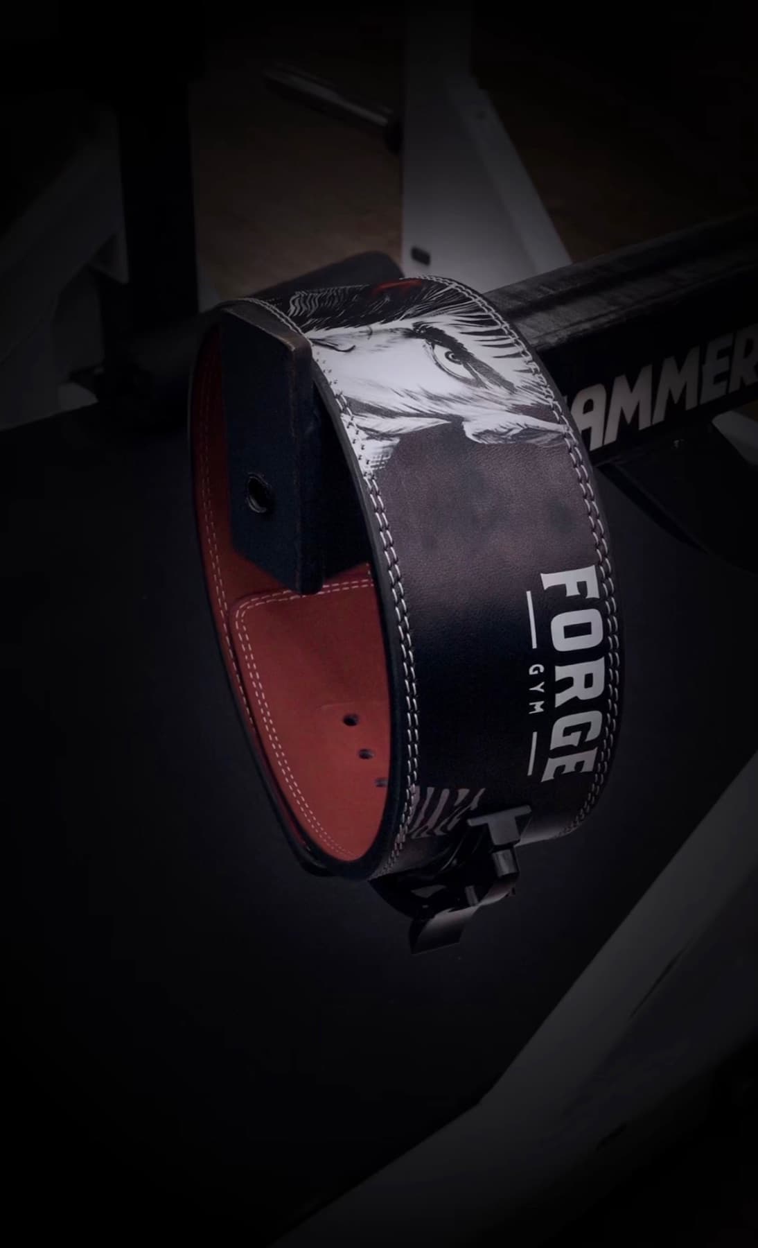 FORGE Berserk lever belt resting on a bench with dark gym lighting.